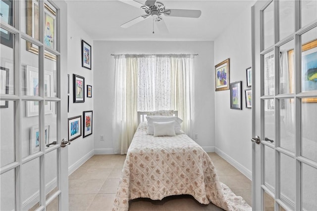 bedroom featuring light tile patterned floors, ceiling fan, and baseboards