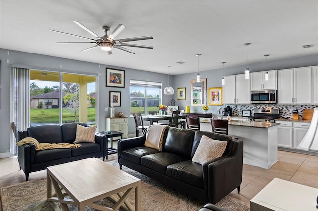 living room featuring ceiling fan, visible vents, and light tile patterned flooring