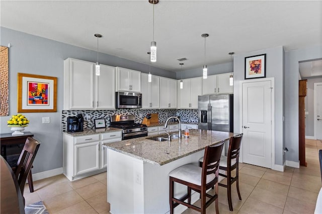 kitchen featuring light tile patterned floors, visible vents, decorative backsplash, stainless steel appliances, and a sink