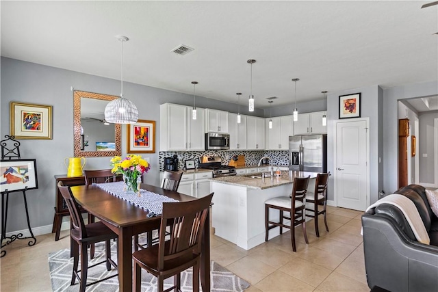 dining area featuring light tile patterned floors, baseboards, and visible vents