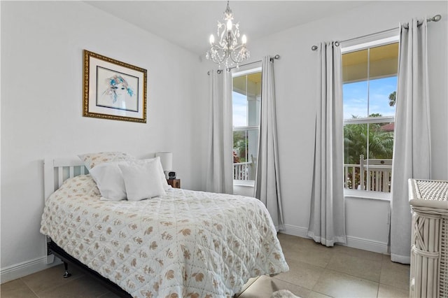 tiled bedroom featuring an inviting chandelier and baseboards