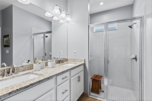 full bathroom with a sink, a shower stall, and double vanity