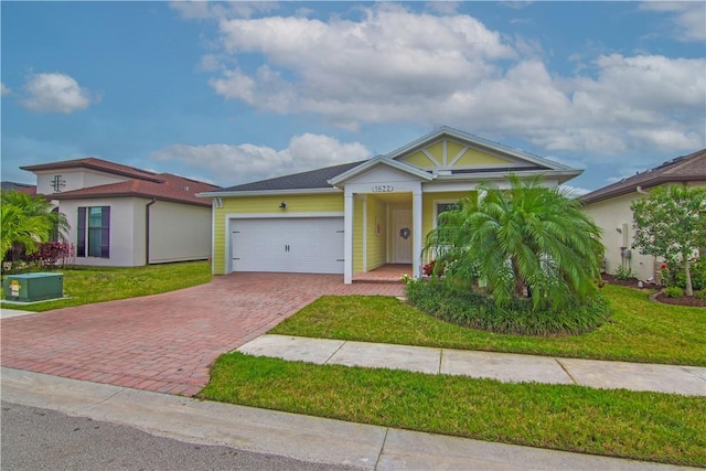 view of front of house featuring decorative driveway, an attached garage, and a front lawn