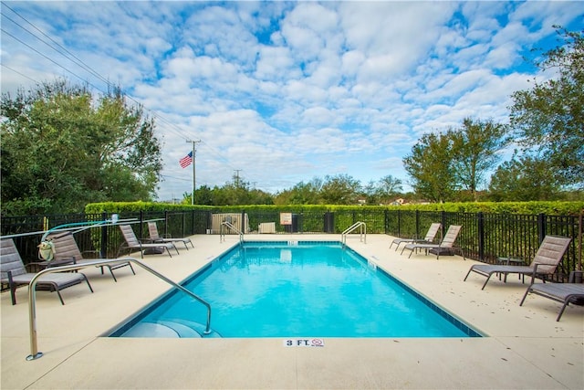 pool with a patio area and fence