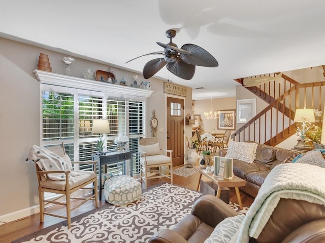 living room featuring hardwood / wood-style floors and ceiling fan with notable chandelier