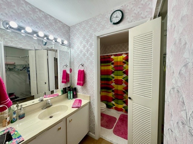 bathroom with toilet, vanity, and walk in shower