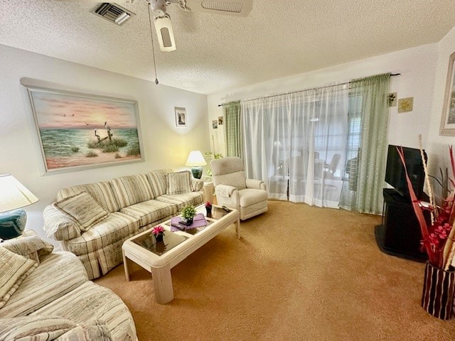 living room featuring a textured ceiling, carpet flooring, and ceiling fan