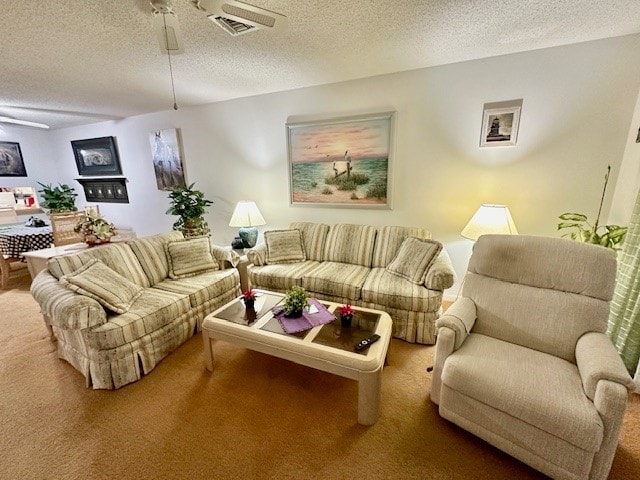 living room with carpet flooring, a textured ceiling, and ceiling fan