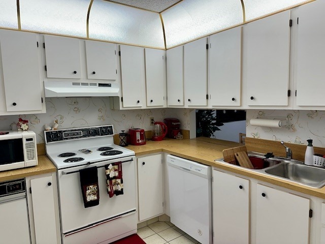 kitchen with white cabinetry, white appliances, sink, and light tile patterned flooring