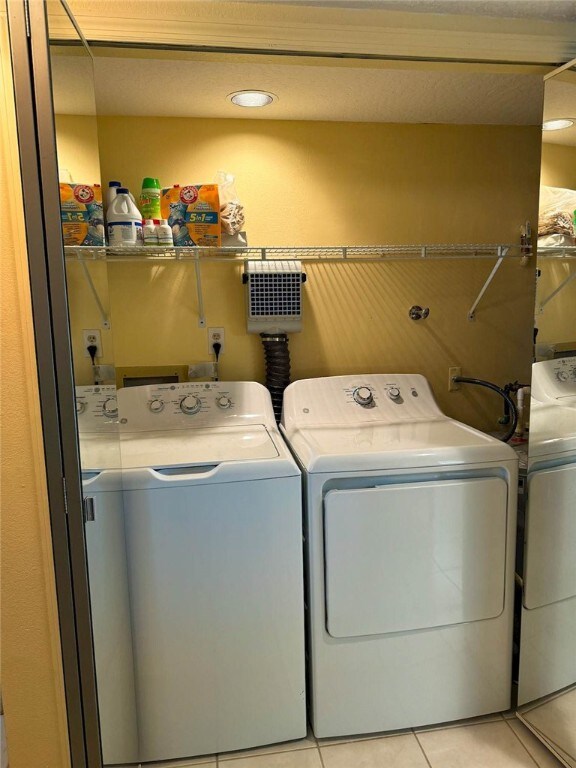 laundry area featuring washer and dryer and light tile patterned floors