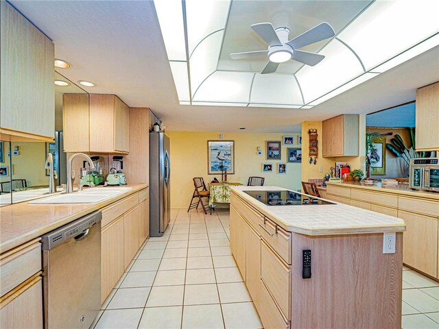 kitchen with stainless steel appliances, sink, light tile patterned floors, a kitchen island, and light brown cabinets