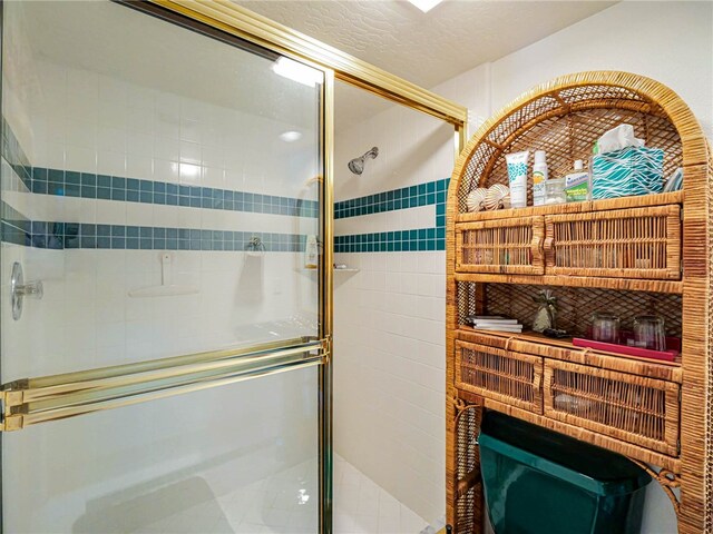 bathroom featuring a shower with door and a textured ceiling