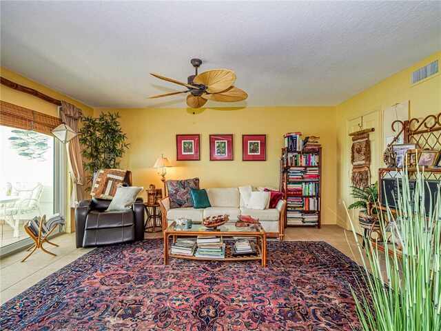 tiled living room with a textured ceiling and ceiling fan