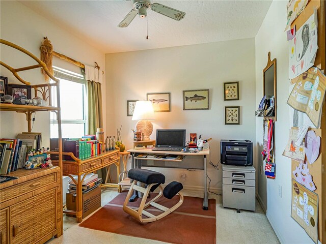 carpeted office featuring a textured ceiling and ceiling fan