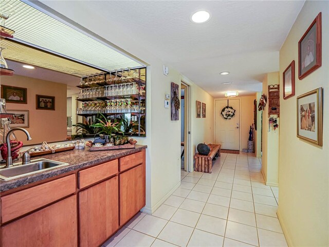 bar with sink and light tile patterned floors