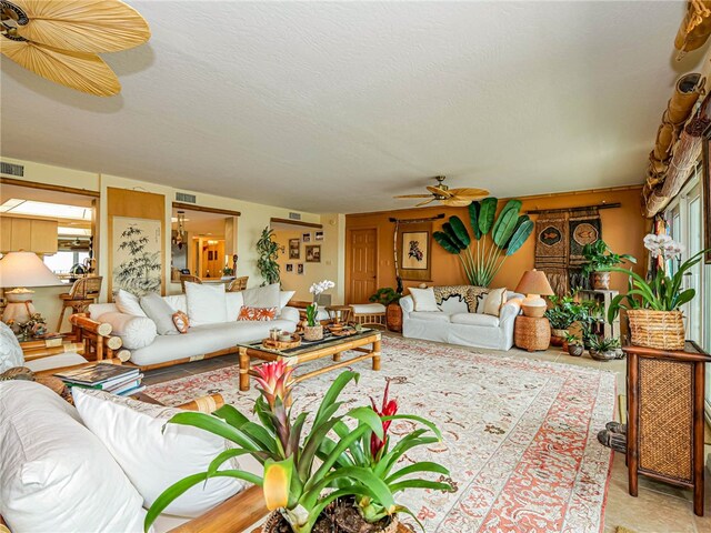 living room with a healthy amount of sunlight, ceiling fan, and a textured ceiling