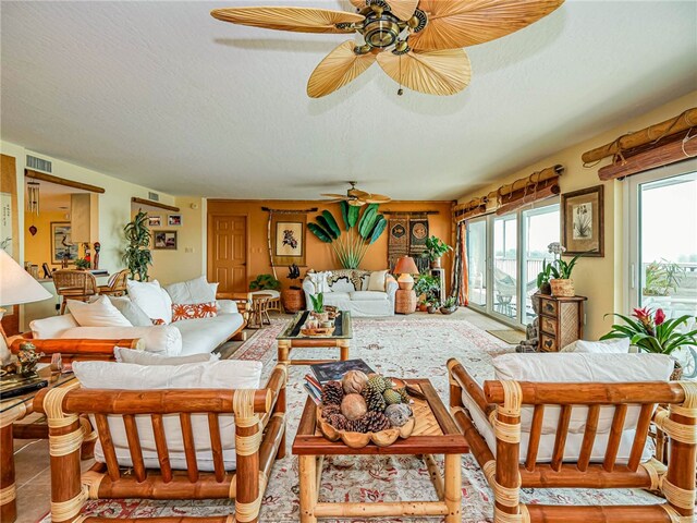 living room featuring ceiling fan, tile patterned flooring, and a textured ceiling