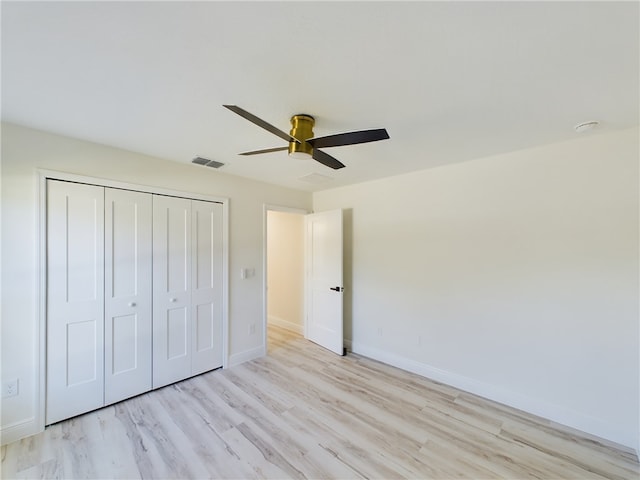 unfurnished bedroom featuring ceiling fan, light hardwood / wood-style floors, and a closet