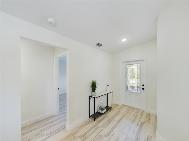 foyer with vaulted ceiling and light hardwood / wood-style flooring