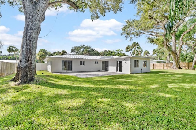 back of house featuring a patio area and a lawn