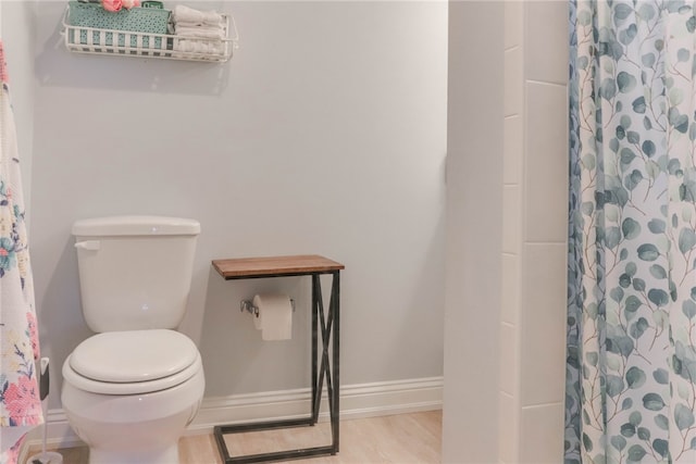 bathroom featuring toilet, hardwood / wood-style floors, and a shower with shower curtain