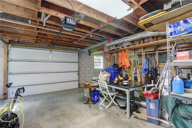 garage featuring concrete block wall and a garage door opener