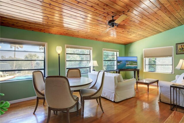 dining room with vaulted ceiling, plenty of natural light, and wood finished floors