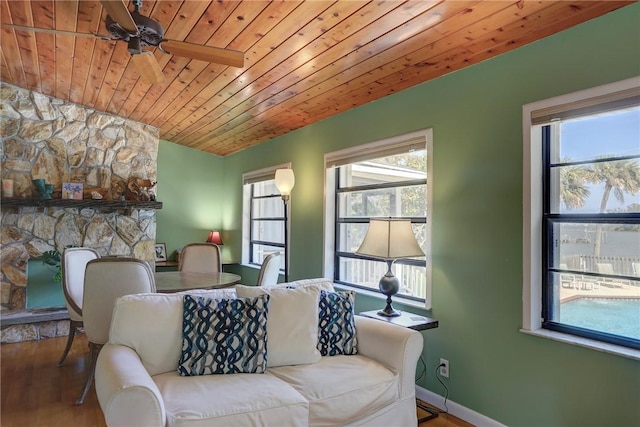 living area with wood ceiling, a healthy amount of sunlight, baseboards, and wood finished floors