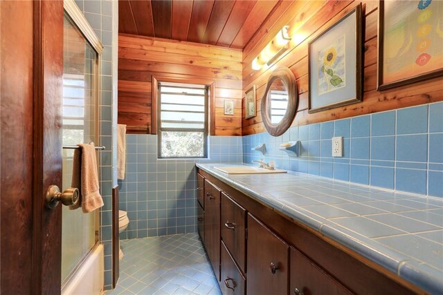 bathroom featuring tile walls, toilet, vanity, wooden ceiling, and tile patterned floors