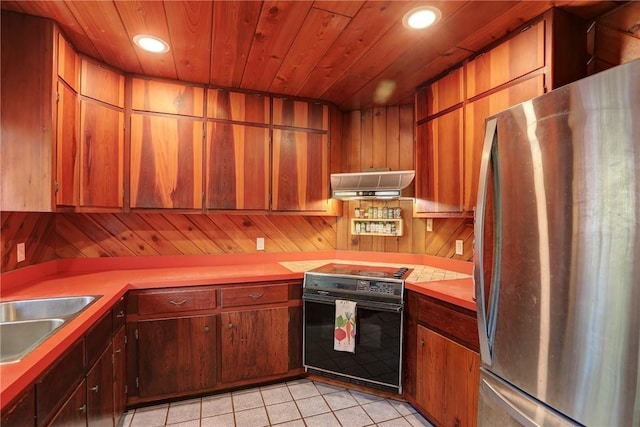 kitchen with light tile patterned floors, freestanding refrigerator, wood ceiling, range, and under cabinet range hood