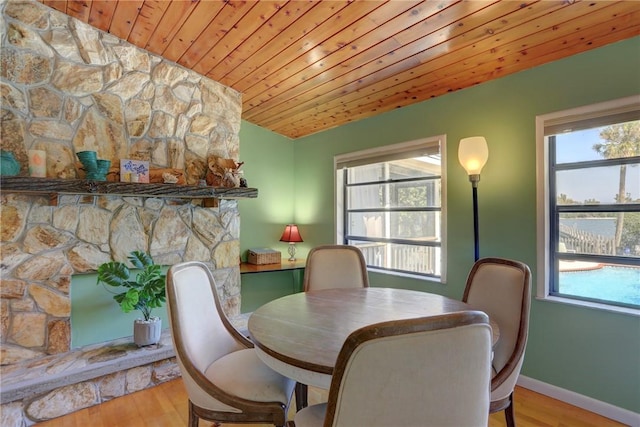 dining area featuring wooden ceiling, plenty of natural light, baseboards, and wood finished floors