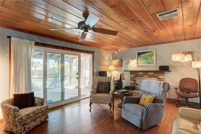 living area with wooden ceiling, visible vents, a fireplace, and wood finished floors