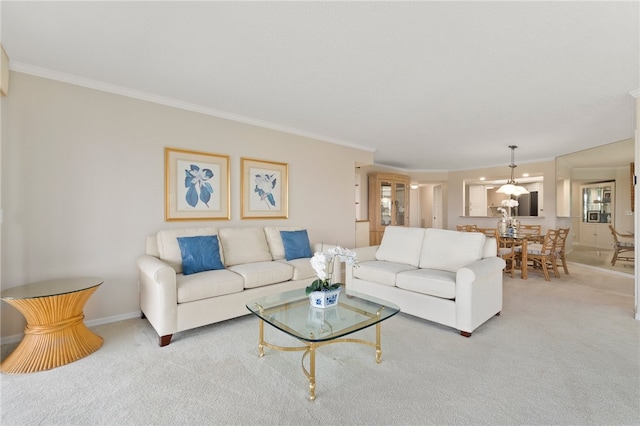 living room featuring an inviting chandelier, carpet floors, and ornamental molding