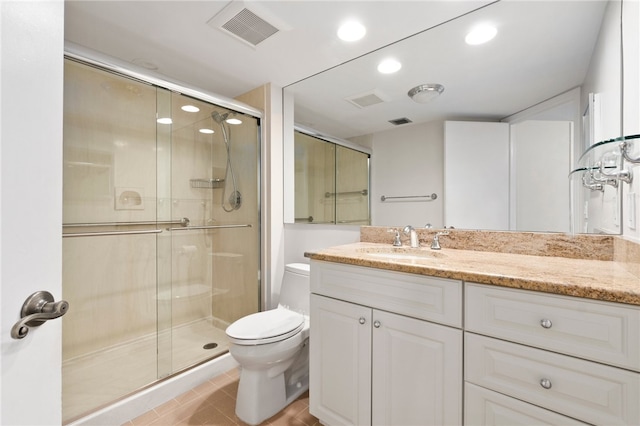 bathroom with tile patterned floors, vanity, toilet, and an enclosed shower