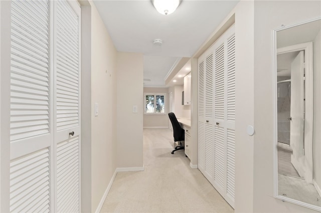 corridor featuring light colored carpet