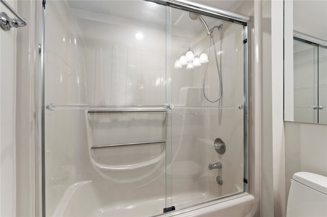 bathroom with shower / bath combination with glass door and toilet