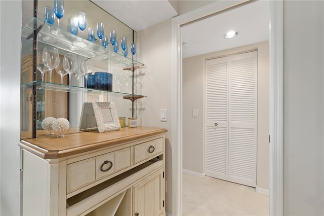 bar featuring light carpet and cream cabinetry