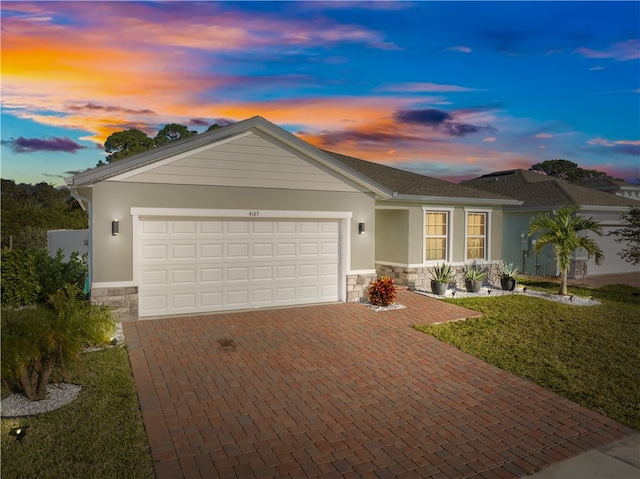 ranch-style home featuring a lawn and a garage