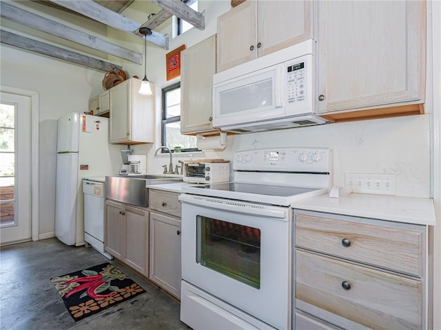 kitchen with light brown cabinetry, white appliances, and hanging light fixtures