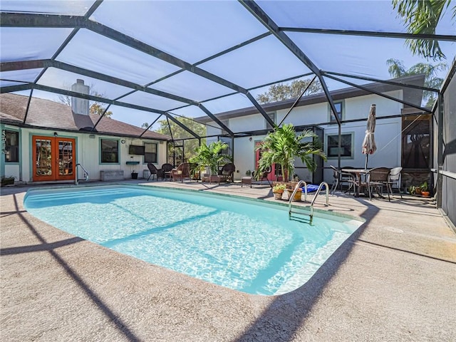 outdoor pool with glass enclosure, french doors, and a patio