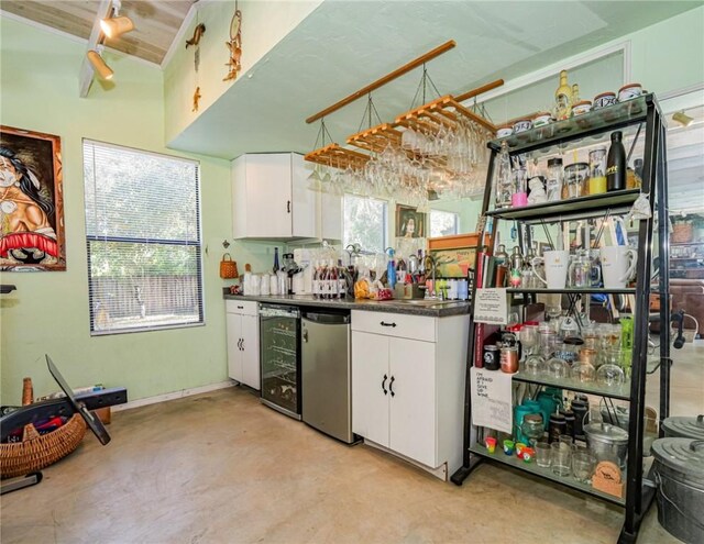 kitchen with kitchen peninsula, stainless steel fridge with ice dispenser, and lofted ceiling