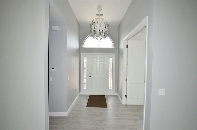 entryway featuring an inviting chandelier and light wood-type flooring