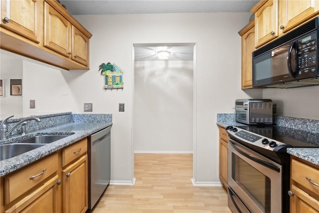 25 Plantation Dr Unit 201, Vero Beach, FL 32966 - kitchen with stainless steel appliances, a sink, light wood-style flooring, light stone counters, and baseboards