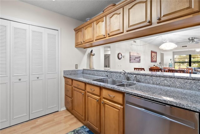 25 Plantation Dr Unit 201, Vero Beach, FL 32966 - kitchen featuring dishwasher, a sink, light wood finished floors, stone counters, and a textured ceiling