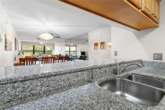 25 Plantation Dr Unit 201, Vero Beach, FL 32966 - kitchen featuring a sink, stone countertops, a chandelier, and decorative light fixtures