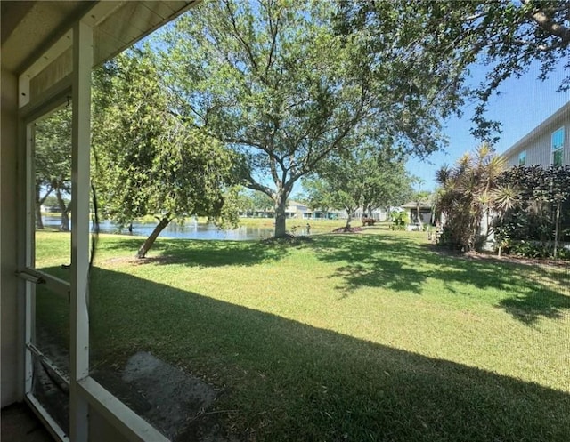 view of green lawn with a water view