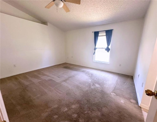 carpeted spare room featuring a textured ceiling, ceiling fan, and vaulted ceiling