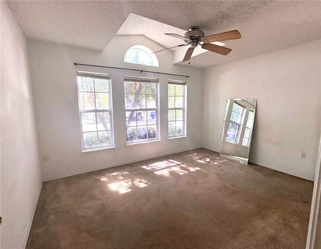 spare room featuring a textured ceiling, lofted ceiling, ceiling fan, and carpet flooring