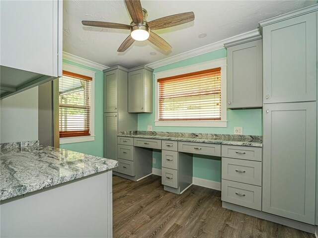 kitchen with dark wood-style floors, crown molding, light stone counters, and a ceiling fan