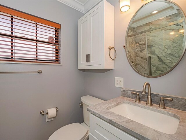 full bath with toilet, a marble finish shower, ornamental molding, and vanity